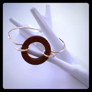 Gold bracelet with wood circle detail.
